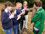 Local school children and Group Leader Sue Searle discuss how they are studying the wildlife in the woodland leaf litter.