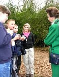 Local school children and Group Leader Sue Searle discuss how they are studying the wildlife in the woodland leaf litter.