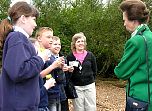 Local school children and Group Leader Sue Searle discuss how they are studying the wildlife in the woodland leaf litter.